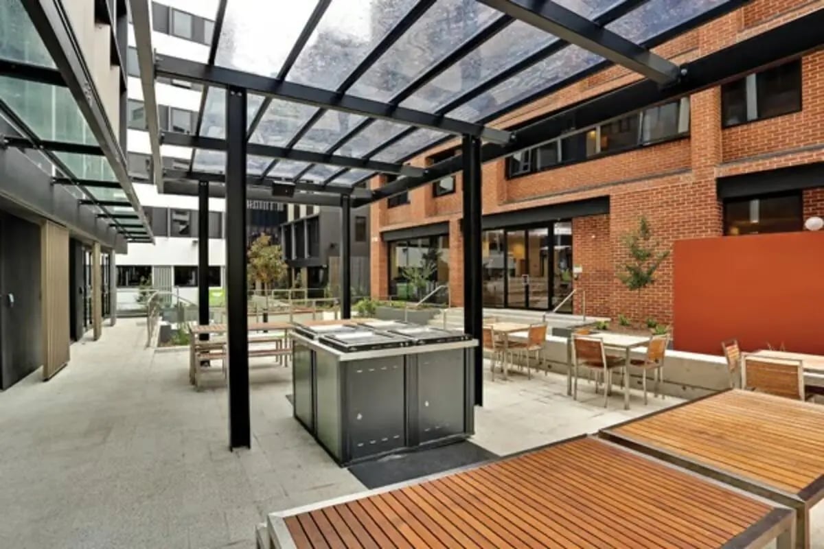 Outdoor dining tables and grills under canopy exterior at Scape Sydney Central in Sydney Student Accommodation