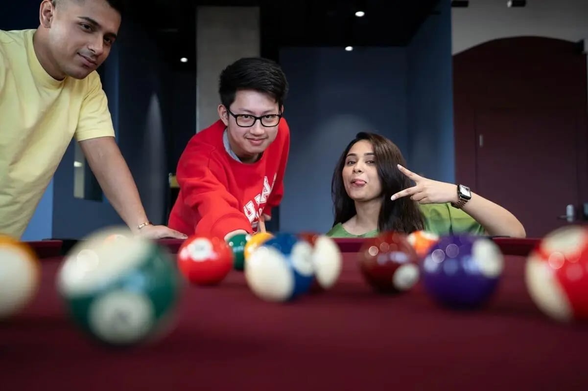 Students playing billiards on a pool table recreation room at Scape Kensington in Sydney Student Accommodation