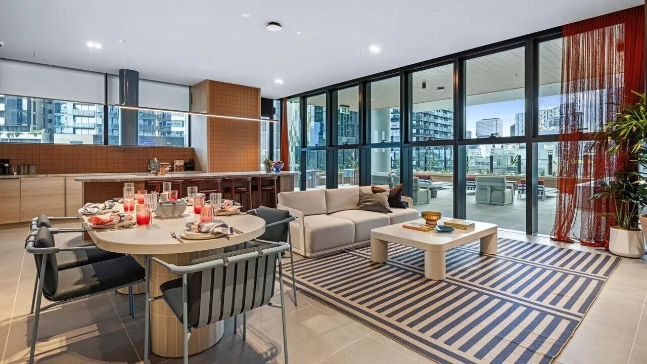 Dining table chairs sofa rug kitchen living area at Indi South Bank in Melbourne Student Accommodation