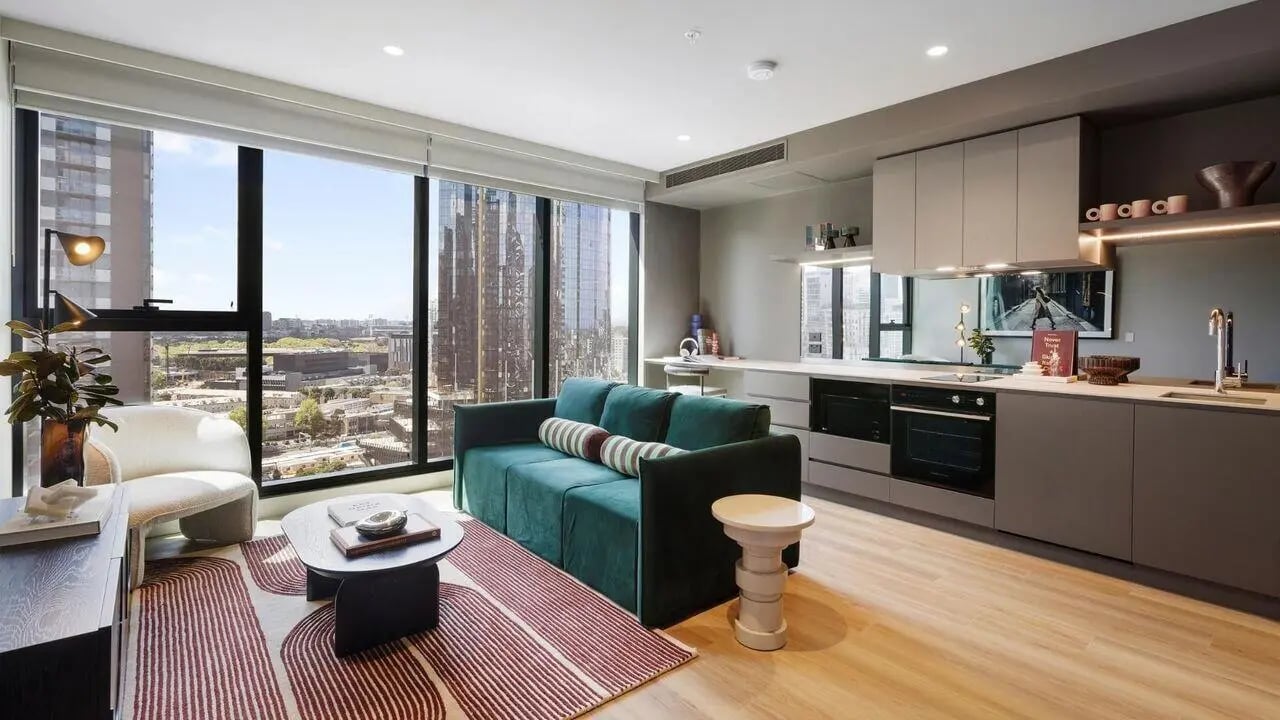 Modern apartment with sofa kitchen and cityscape Living room at Indi South Bank in Melbourne Student Accommodation