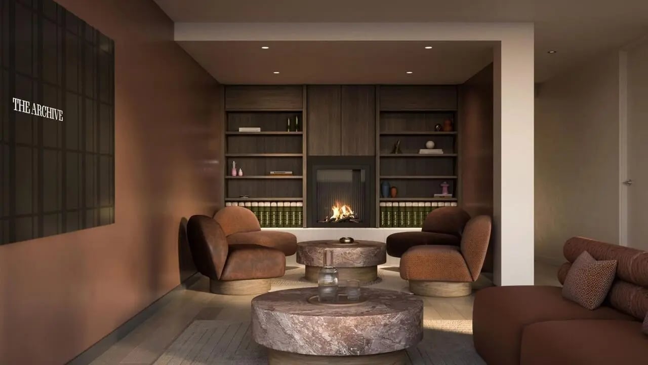 Fireplace bookshelves chairs coffee tables lounge area at The Archive - Residential Living in Melbourne Student Accommodation