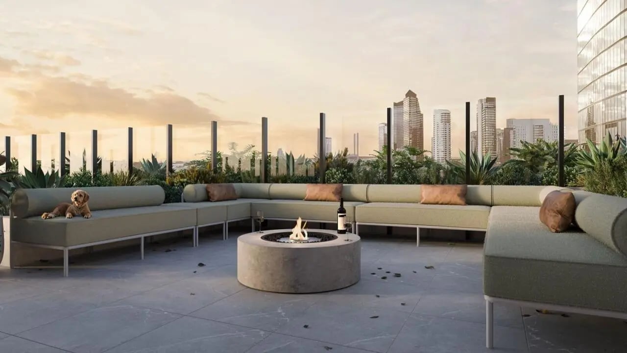 U-shaped sofa fire pit dog and city skyline outdoor lounge at The Archive - Residential Living in Melbourne Student Accommodation