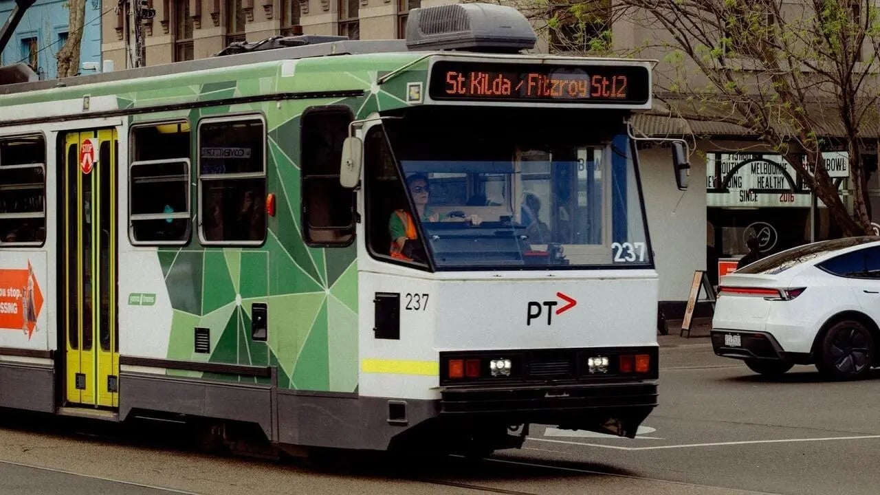 Green tram with driver and destination display exterior at The Archive - Residential Living in Melbourne Student Accommodation