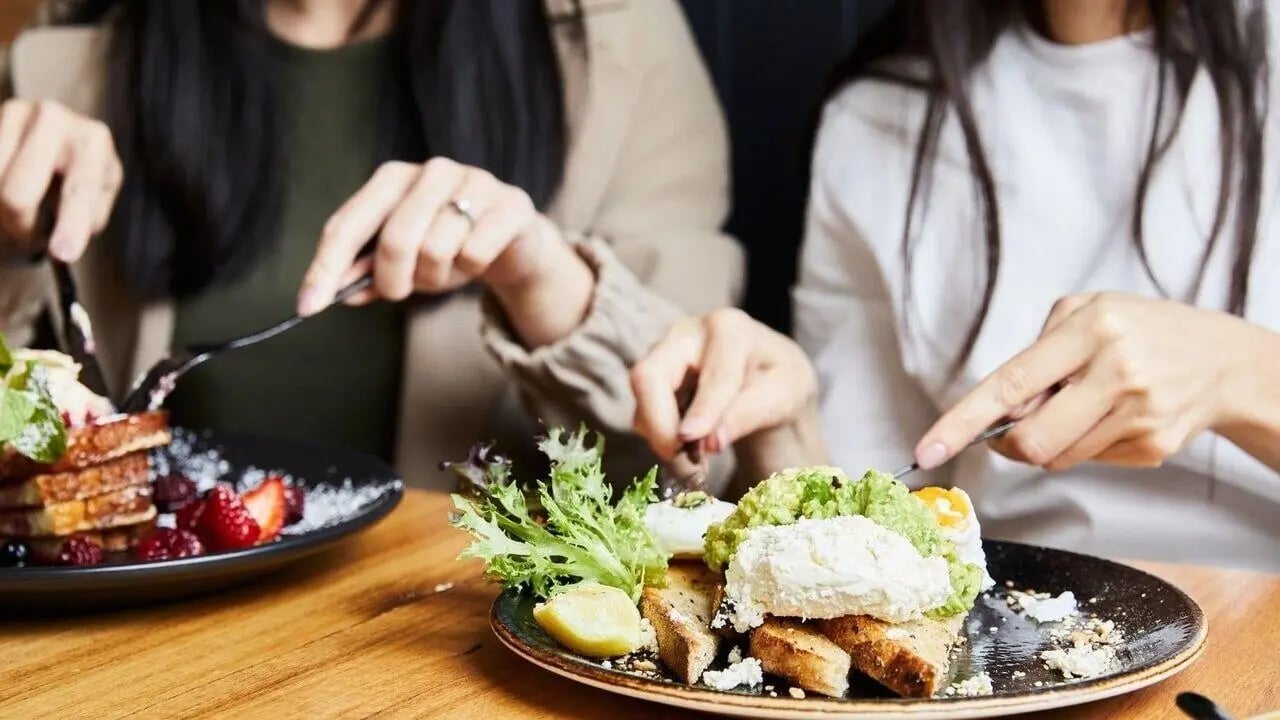 Food on table with people dining dining at West Tower, Melbourne Quarter in Melbourne Student Accommodation