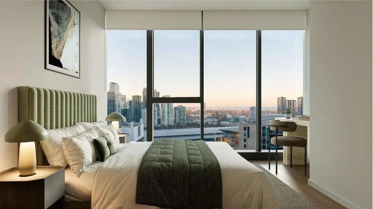 Bed with green headboard desk and cityscape view bedroom at West Tower, Melbourne Quarter in Melbourne Student Accommodation