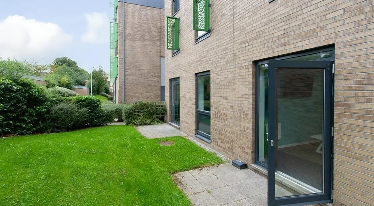 Brick building with green lawn and patio Exterior at The Green in Bradford Student Accommodation