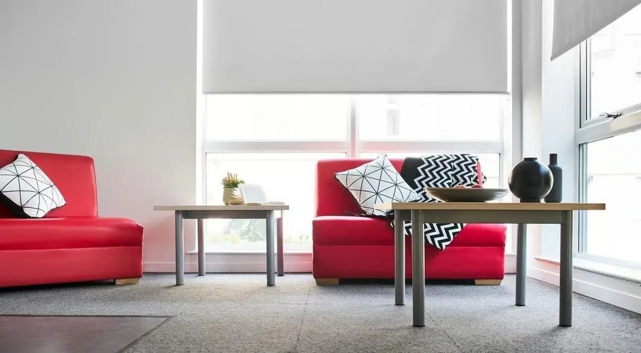 Red sofas black white pillows on floor Living Room at The Green in Bradford Student Accommodation