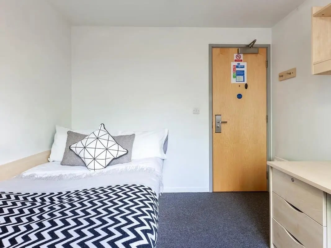 Bed with pillows blanket door desk Bedroom at The Green in Bradford Student Accommodation