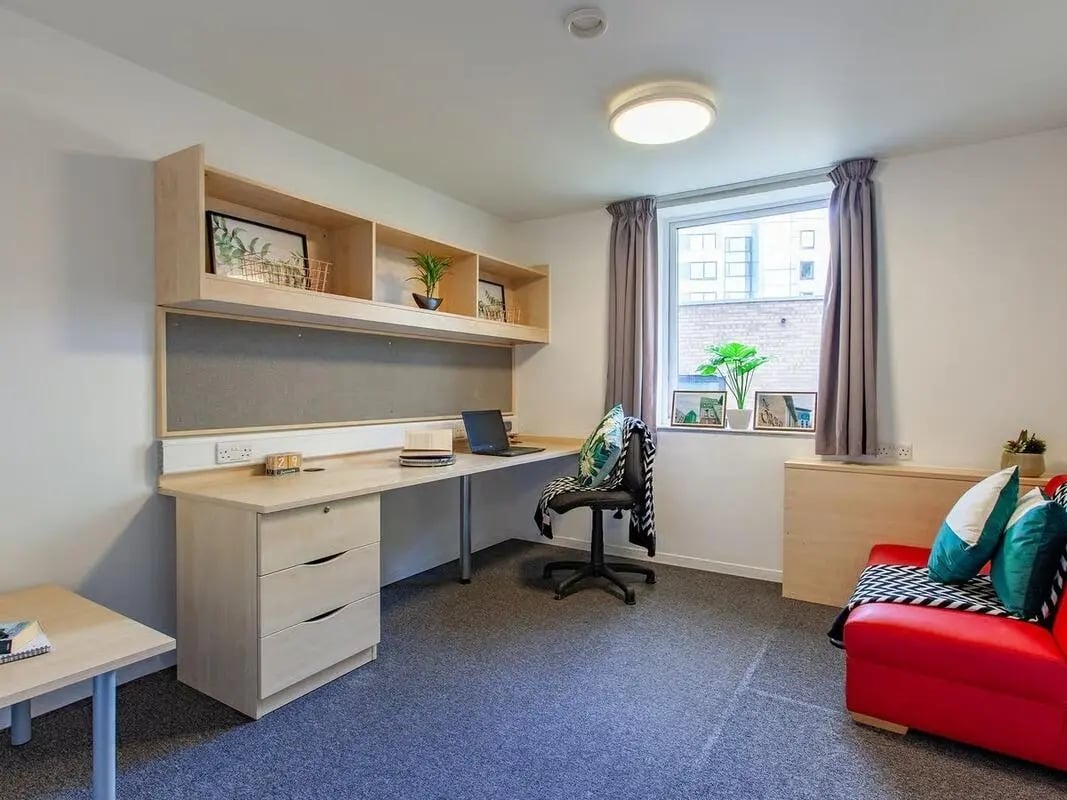 Desk chair shelves laptop couch Red living room at The Green in Bradford Student Accommodation