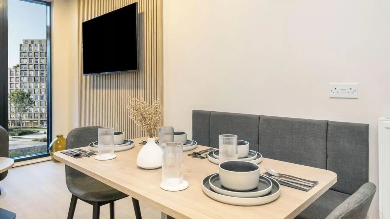 Dining table with place settings and banquette seating dining area at Press House in London Student Accommodation