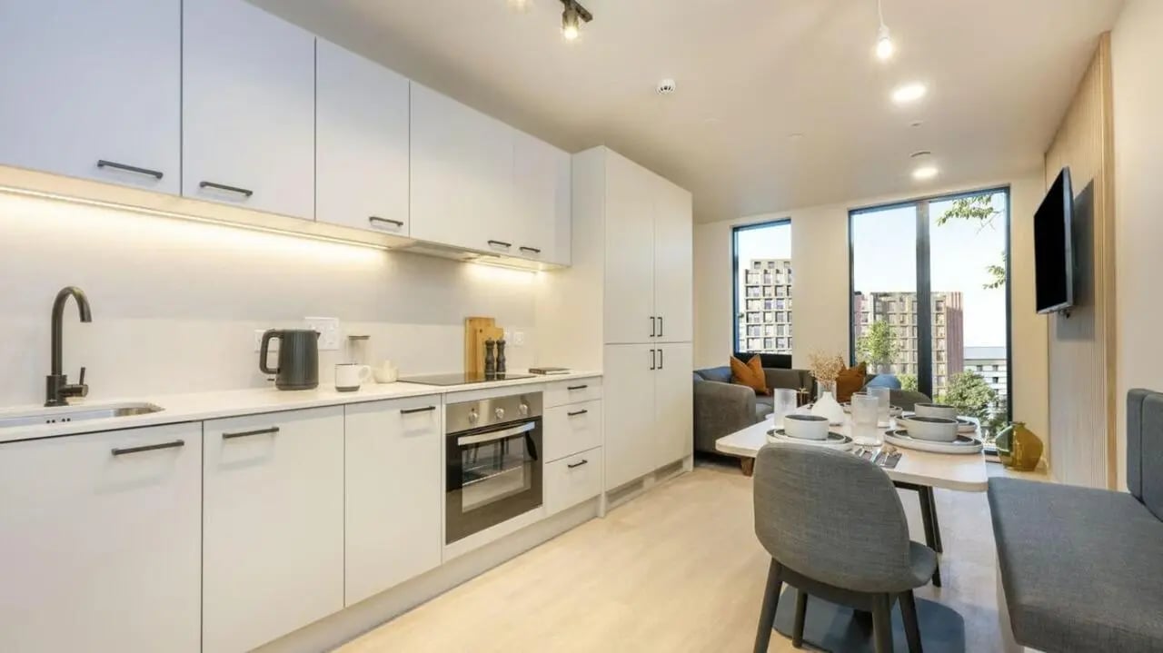 Modern white kitchen and dining area living room at Press House in London Student Accommodation