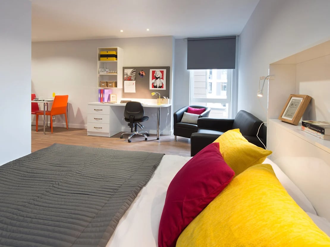 Bed desk chairs and sofa bedroom study living room at Glassyard Building in London Student Accommodation