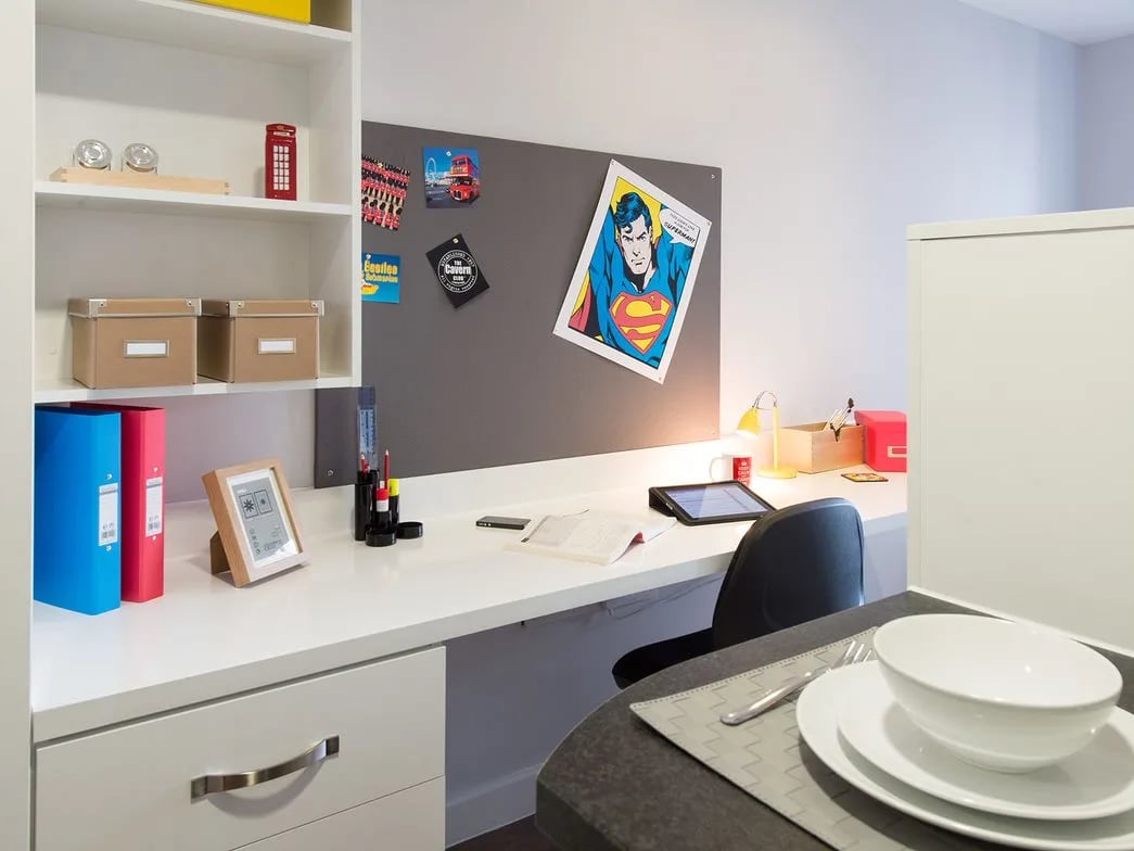 Desk with Superman poster and shelving study area at Glassyard Building in London Student Accommodation