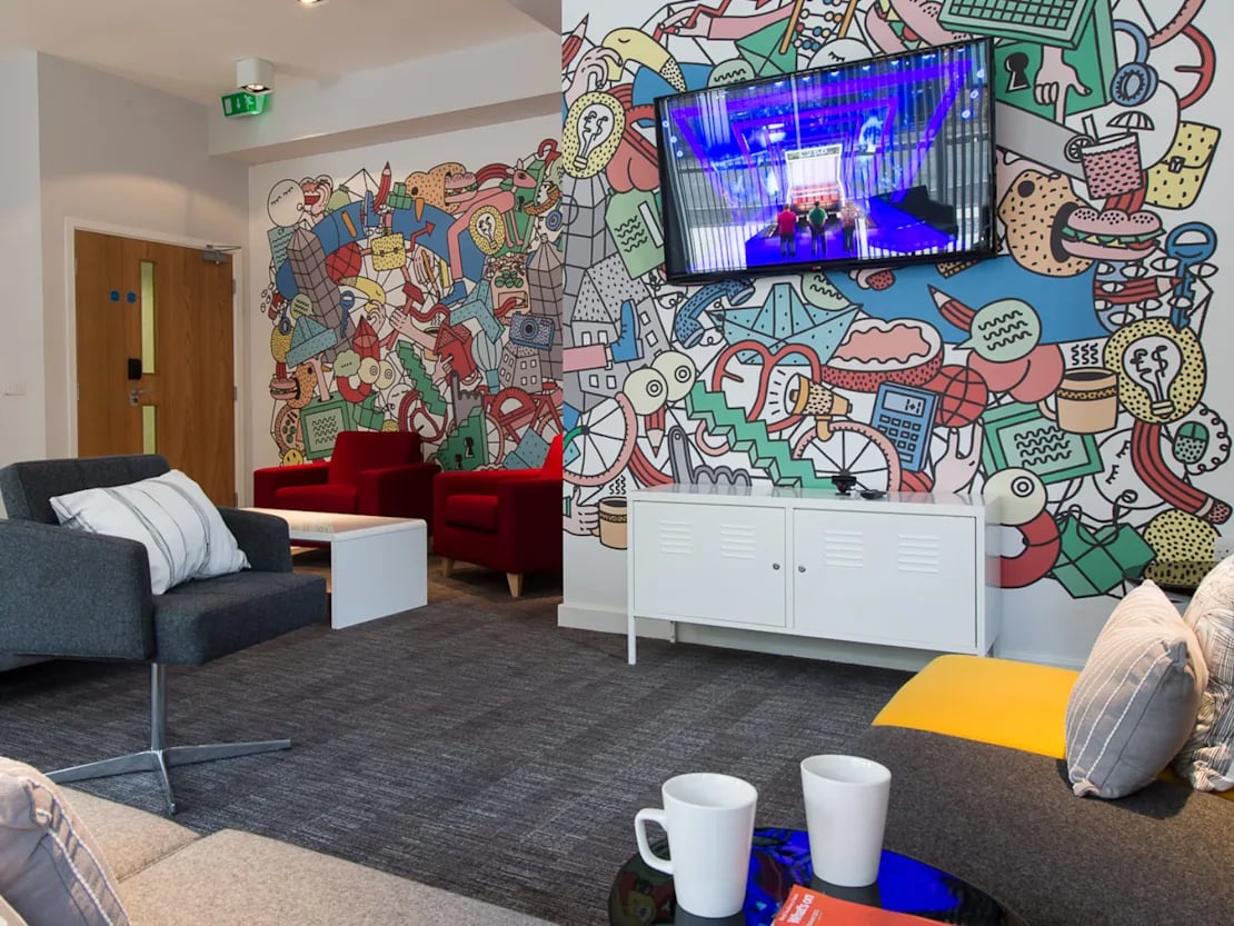Seating TV and colorful mural common area at Glassyard Building in London Student Accommodation