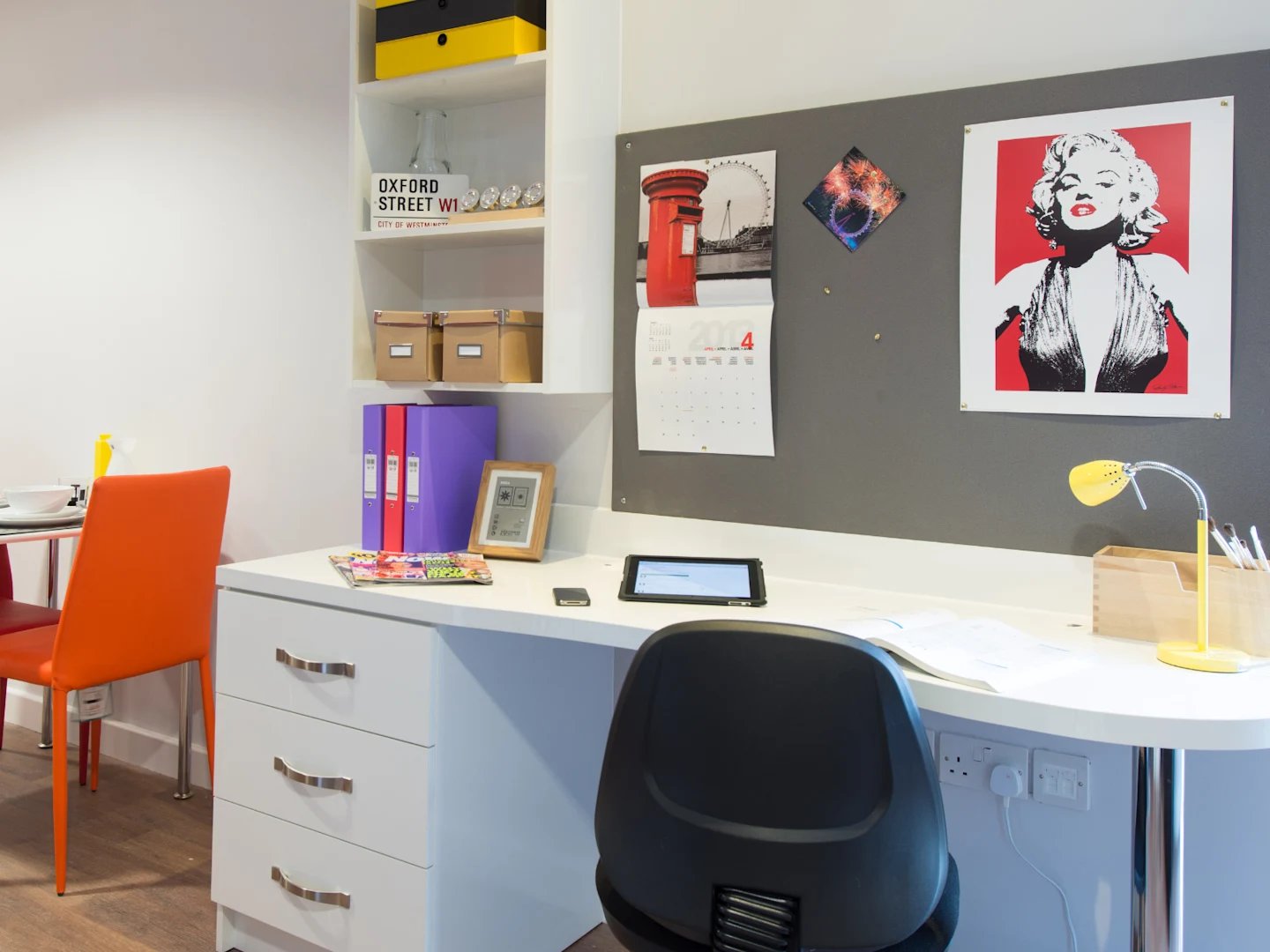 Desk with drawers chair lamp calendar and Marilyn Monroe print study area at Glassyard Building in London Student Accommodation