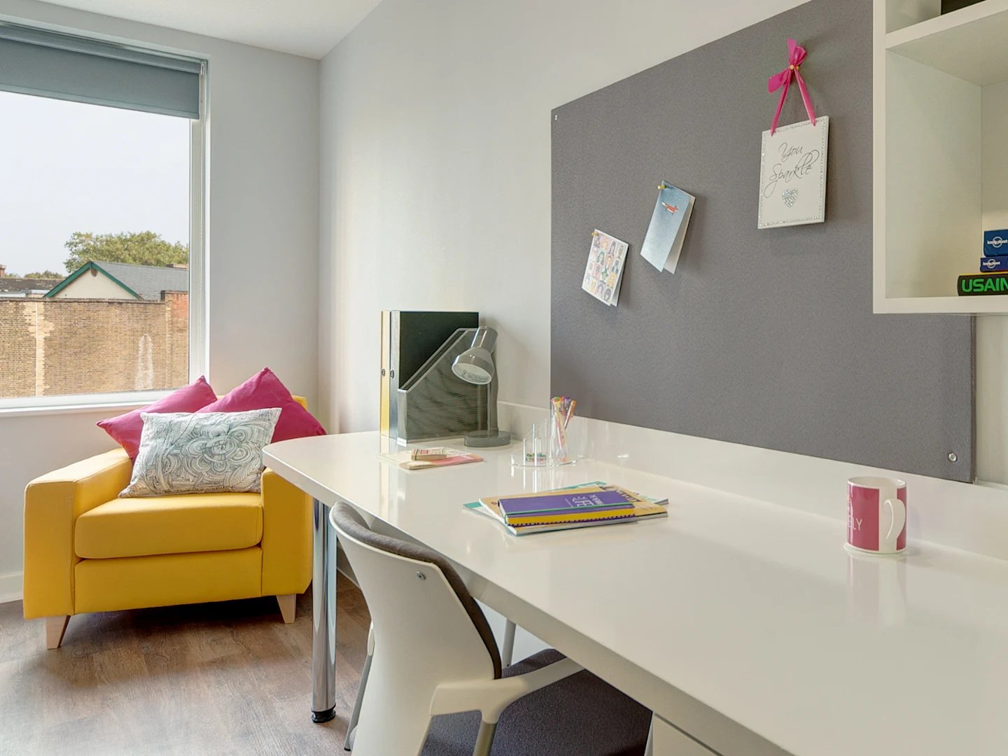 Yellow armchair desk lamp and mug study area at Glassyard Building in London Student Accommodation
