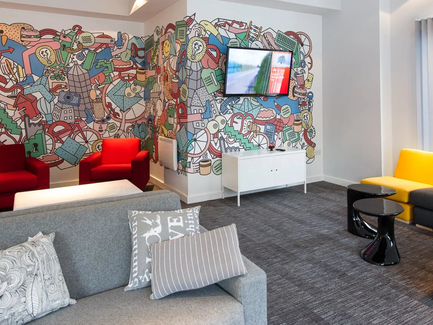 Colorful mural sofas and TV living room at Glassyard Building in London Student Accommodation