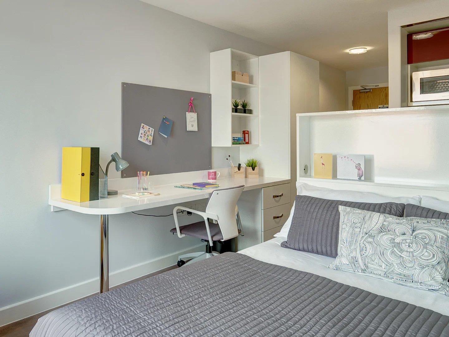 Desk bed and microwave student accommodation bedroom at Glassyard Building in London Student Accommodation
