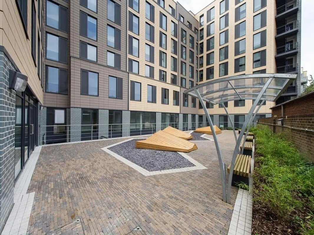Outdoor seating area with benches and wooden features Exterior at Glassyard Building in London Student Accommodation