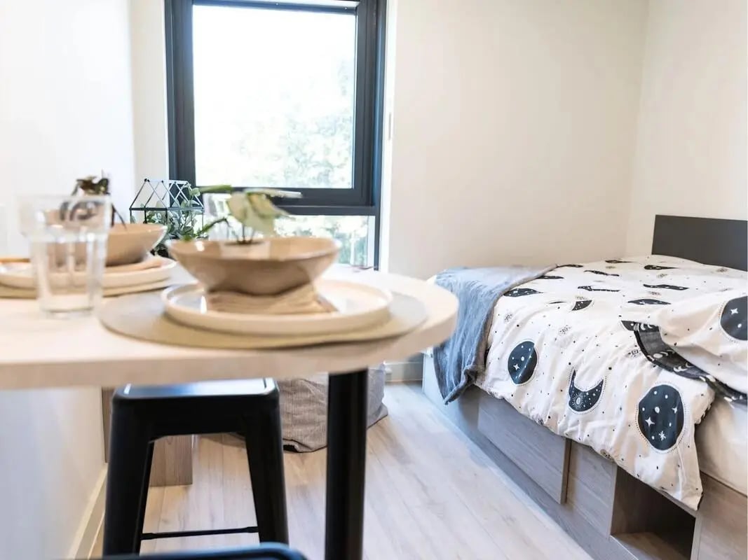 Bedding table with plates and stool bedroom at Stanley Studios - Portsmouth in Portsmouth Student Accommodation