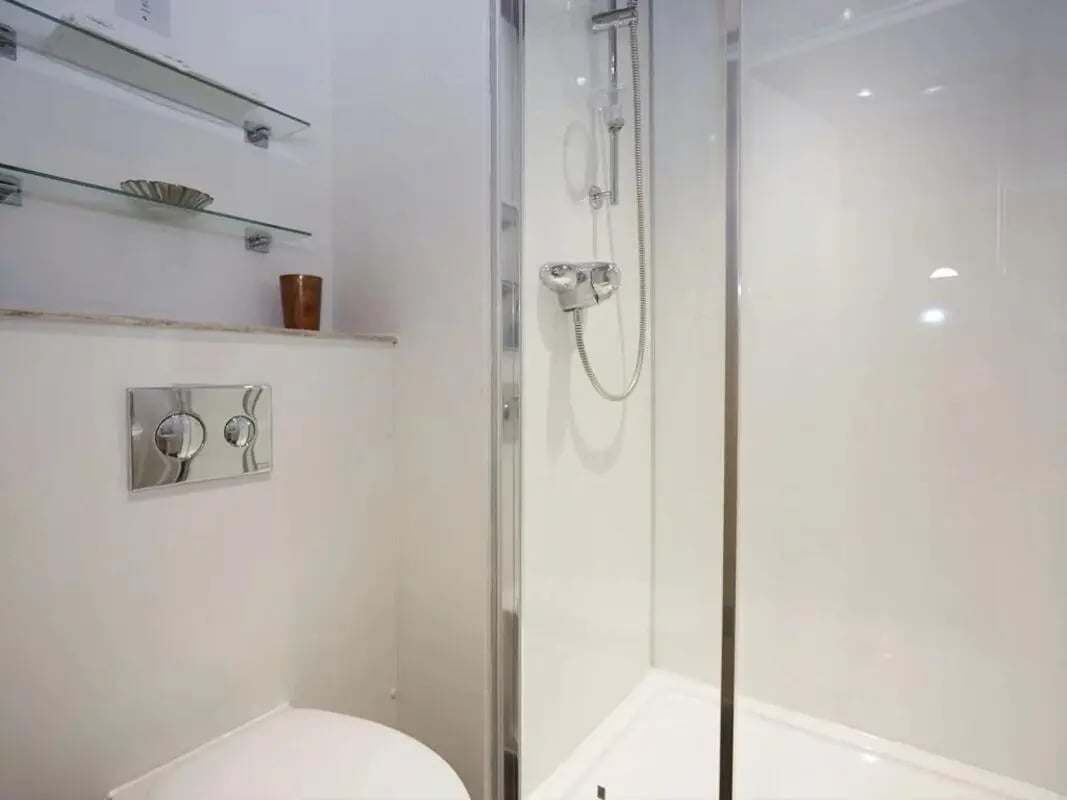 Toilet shower shelves and cup bathroom at Woodside House in Glasgow Student Accommodation