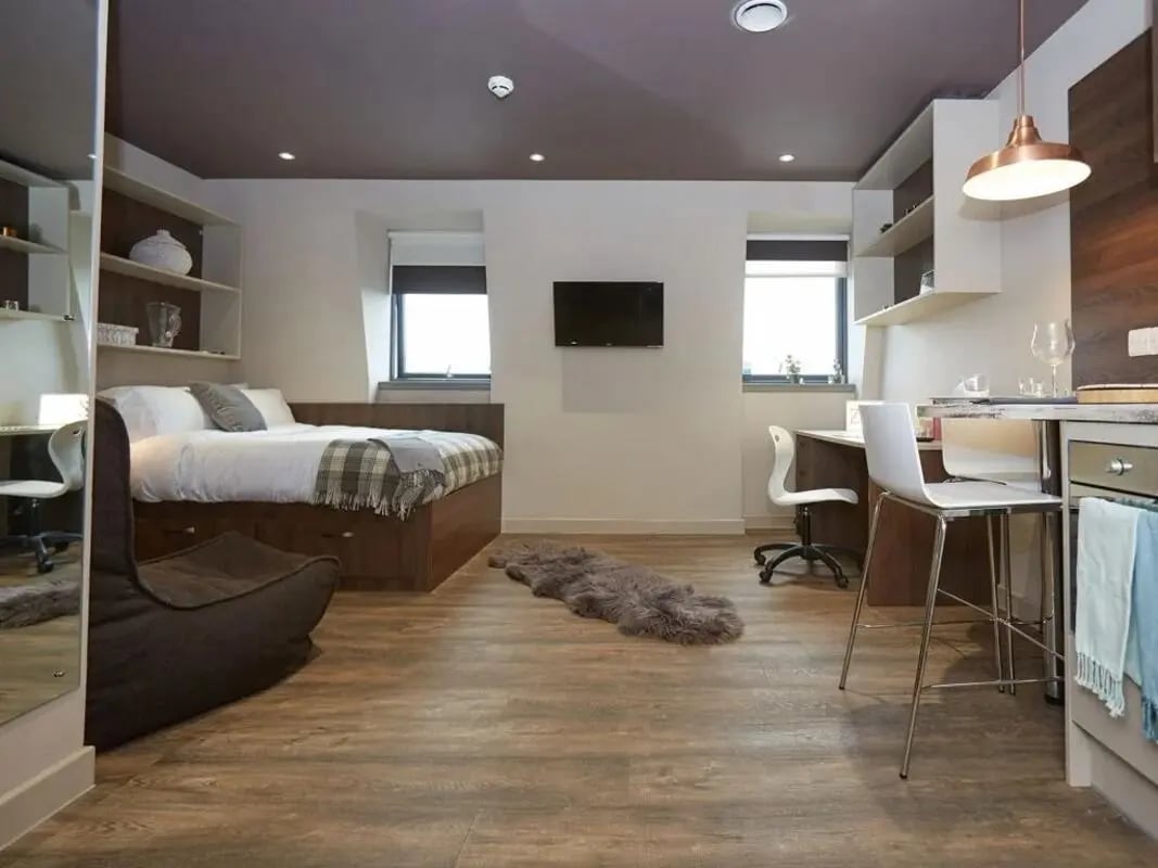 Bed study desk TV and kitchen area studio at Woodside House in Glasgow Student Accommodation