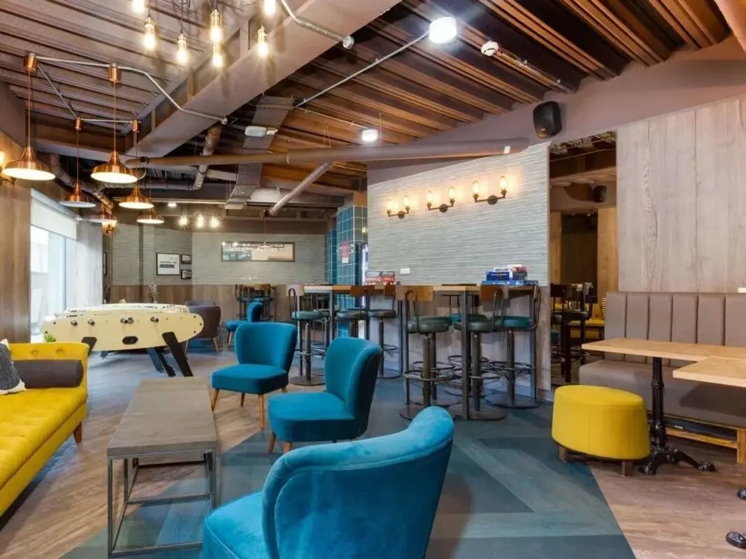 Foosball table couches chairs bar stools communal area at Woodside House in Glasgow Student Accommodation