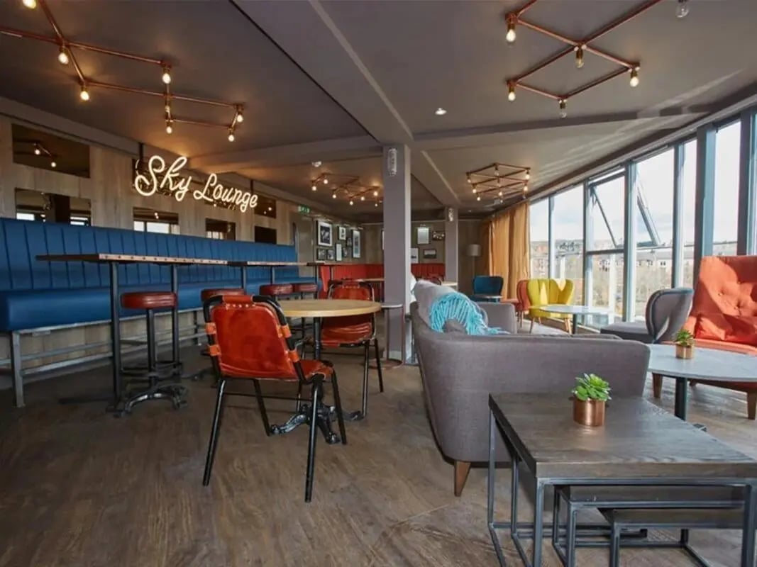 Sky Lounge neon sign sofas tables chairs lounge area at Woodside House in Glasgow Student Accommodation