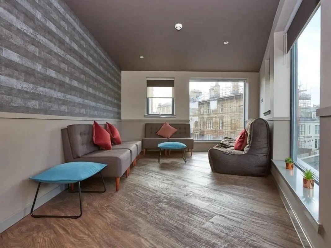 Sofa beanbag ottomans with city view living room at Woodside House in Glasgow Student Accommodation