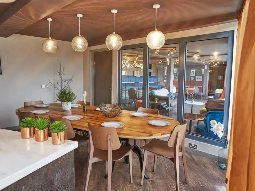 Wooden dining table with place settings and plants dining area at Woodside House in Glasgow Student Accommodation