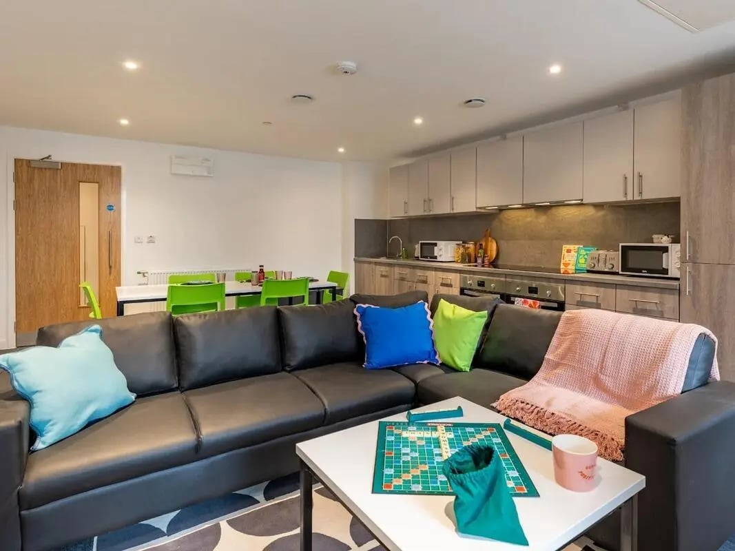 Large sectional sofa with colorful pillows and Scrabble living room at Glassworks in Bristol Student Accommodation