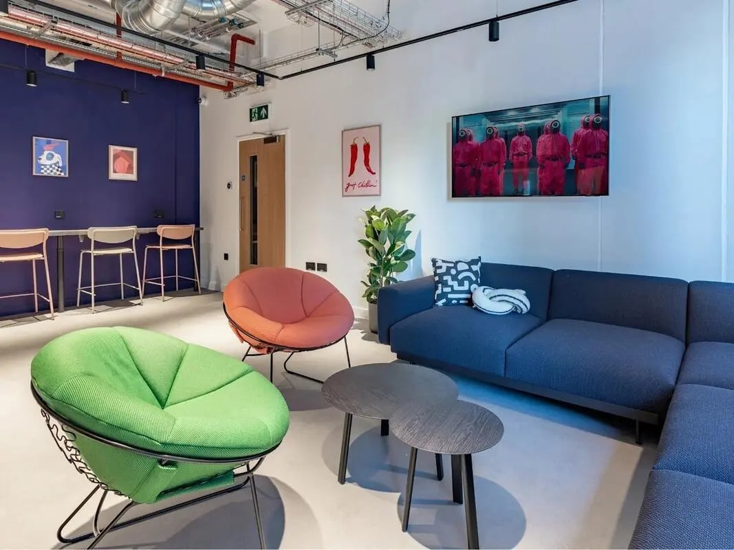 Blue sofa, round chairs, tables, TV living room at Glassworks in Bristol Student Accommodation