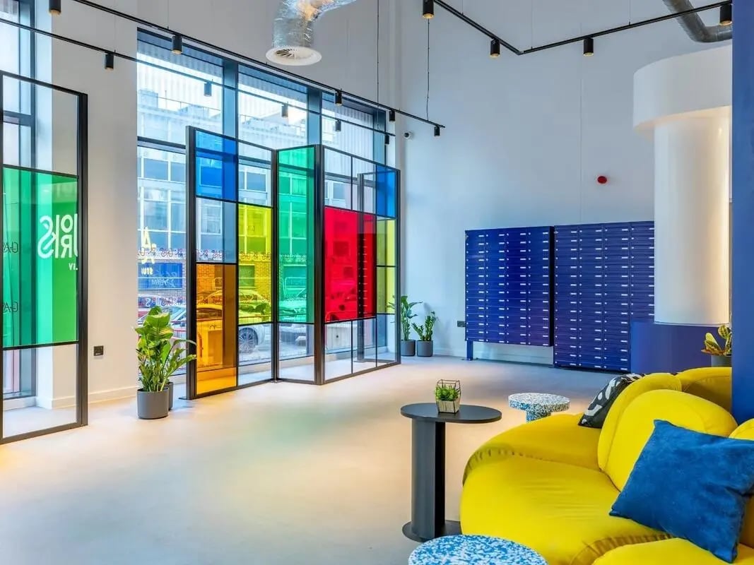 Yellow sofa blue lockers colorful window common area at Glassworks in Bristol Student Accommodation