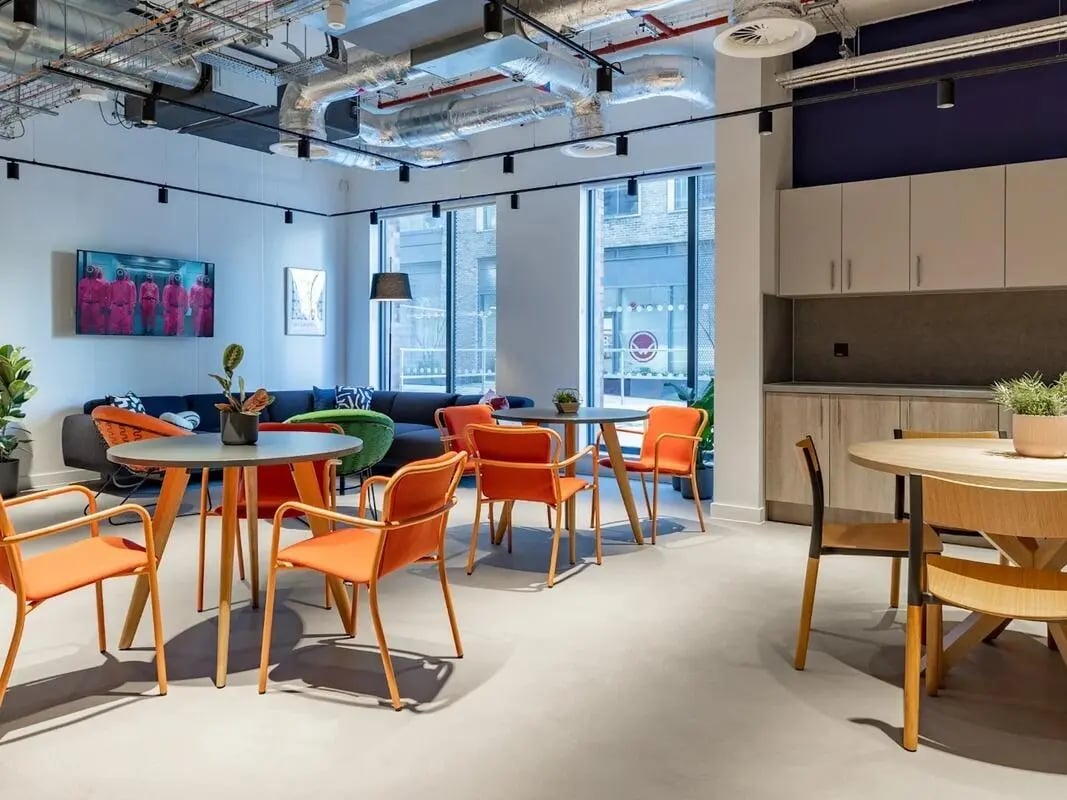 Sofa tables chairs artwork and kitchen common area at Glassworks in Bristol Student Accommodation