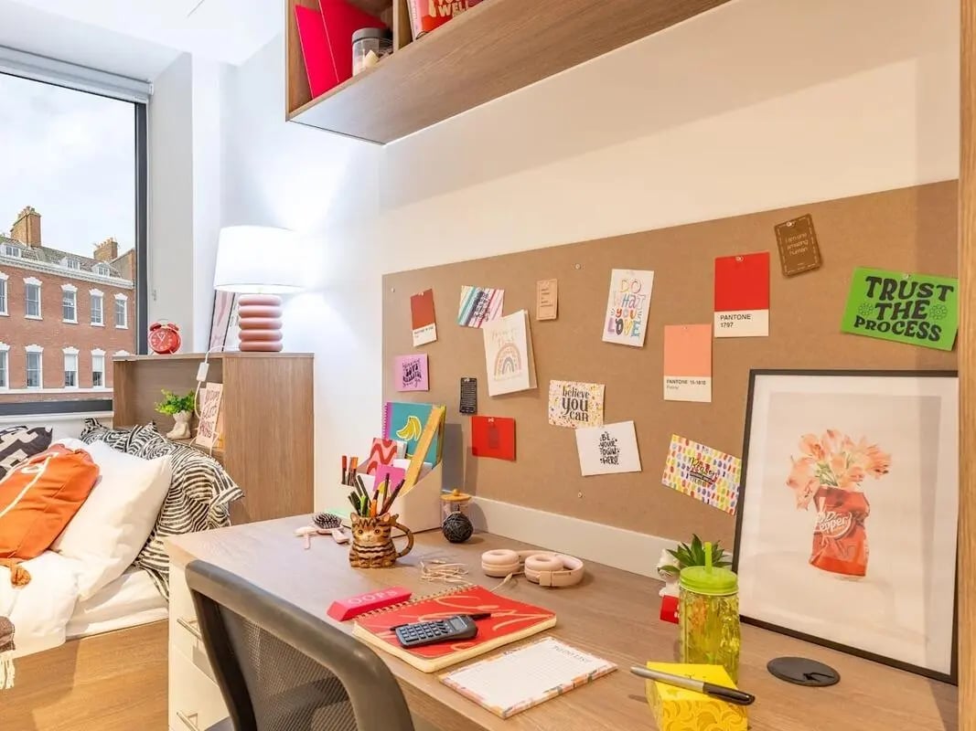 Desk with corkboard bed lamp and window study area at Glassworks in Bristol Student Accommodation