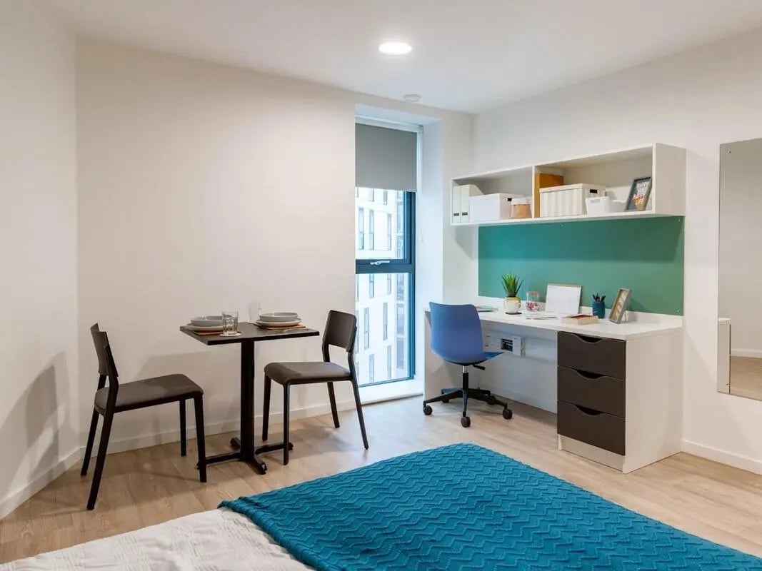 Table chairs desk shelf with boxes study area at Pavilion Court London in London Student Accommodation