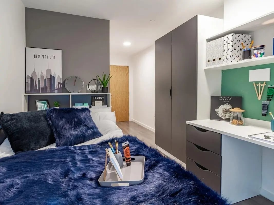 Bed with blue faux fur and desk bedroom at Pavilion Court London in London Student Accommodation