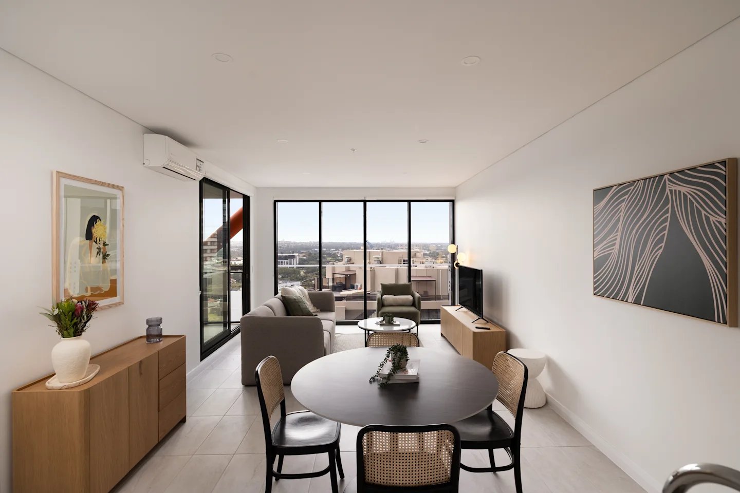 Dining table chairs sofa and artwork living room at UKO Parramatta Central in Sydney Student Accommodation