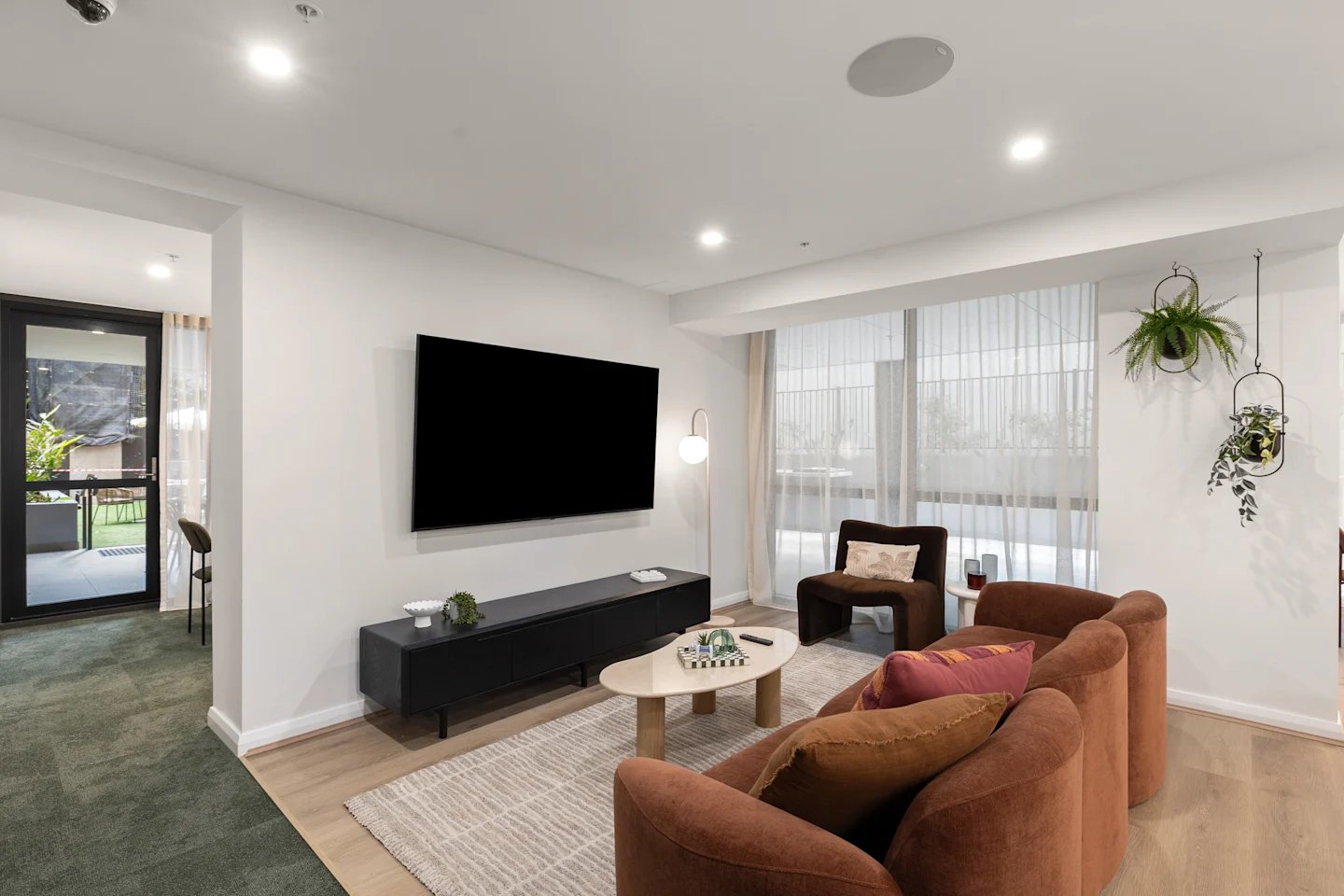 Sofa TV coffee table chair plants living room at UKO Parramatta Central in Sydney Student Accommodation