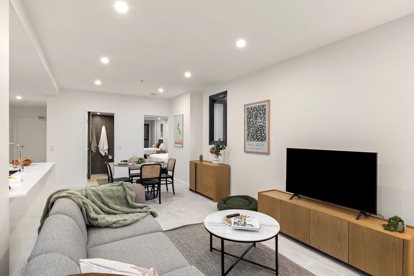 Sofa dining table TV and kitchen living area at UKO Parramatta Central in Sydney Student Accommodation