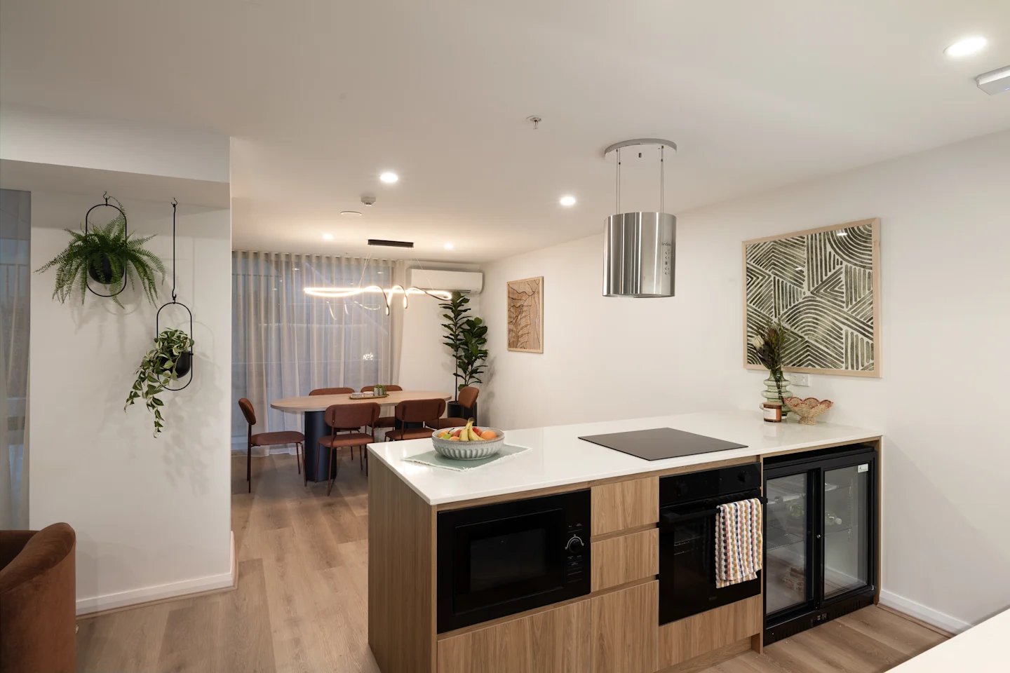 Kitchen island dining table chairs plants and artwork kitchen at UKO Parramatta Central in Sydney Student Accommodation