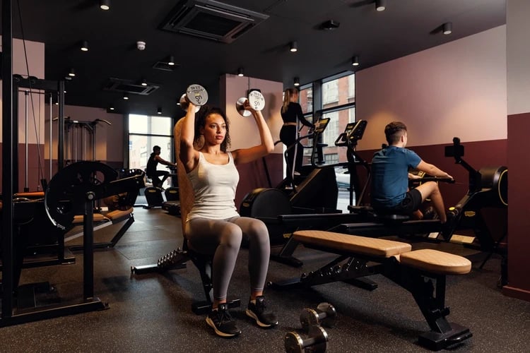 Women lifting weights rowing machine gym at Hayloft Point in London Student Accommodation