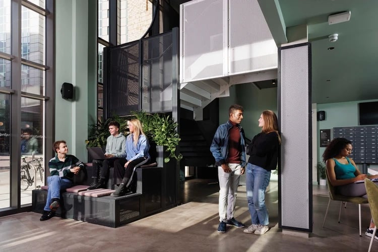 Students talking and working in common area living room at Hayloft Point in London Student Accommodation