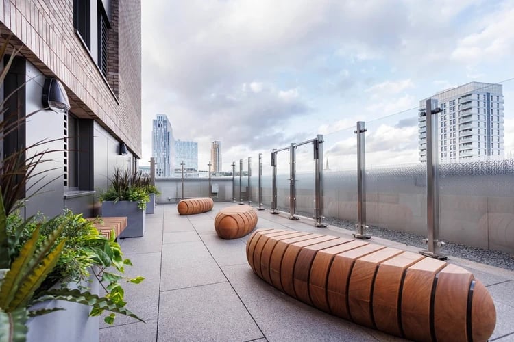 Wooden benches glass railing and city view outdoor area at Hayloft Point in London Student Accommodation