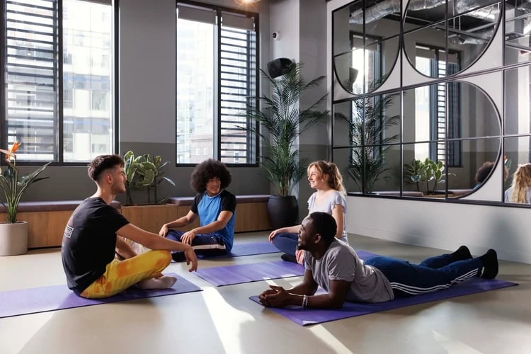 Students exercising on yoga mats communal area at Hayloft Point in London Student Accommodation