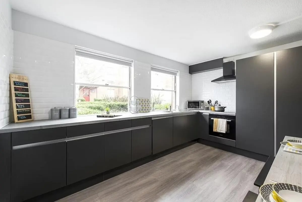 Modern kitchen with dark cabinets and white tiled backsplash kitchen at Regents Court in Leicester Student Accommodation