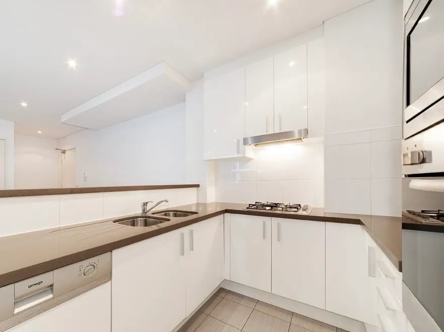 White cabinets sink dishwasher stovetop oven kitchen at Belong Waterloo in Sydney Student Accommodation