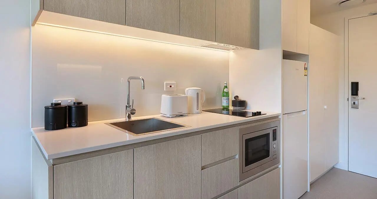 Modern student kitchenette with sink toaster microwave and fridge kitchen at Iglu Waterloo in Sydney Student Accommodation