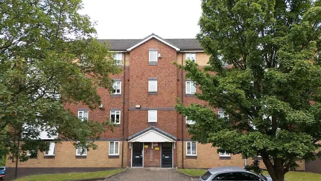 Brick building with trees entrance exterior at Woodhouse Flats in Leeds Student Accommodation