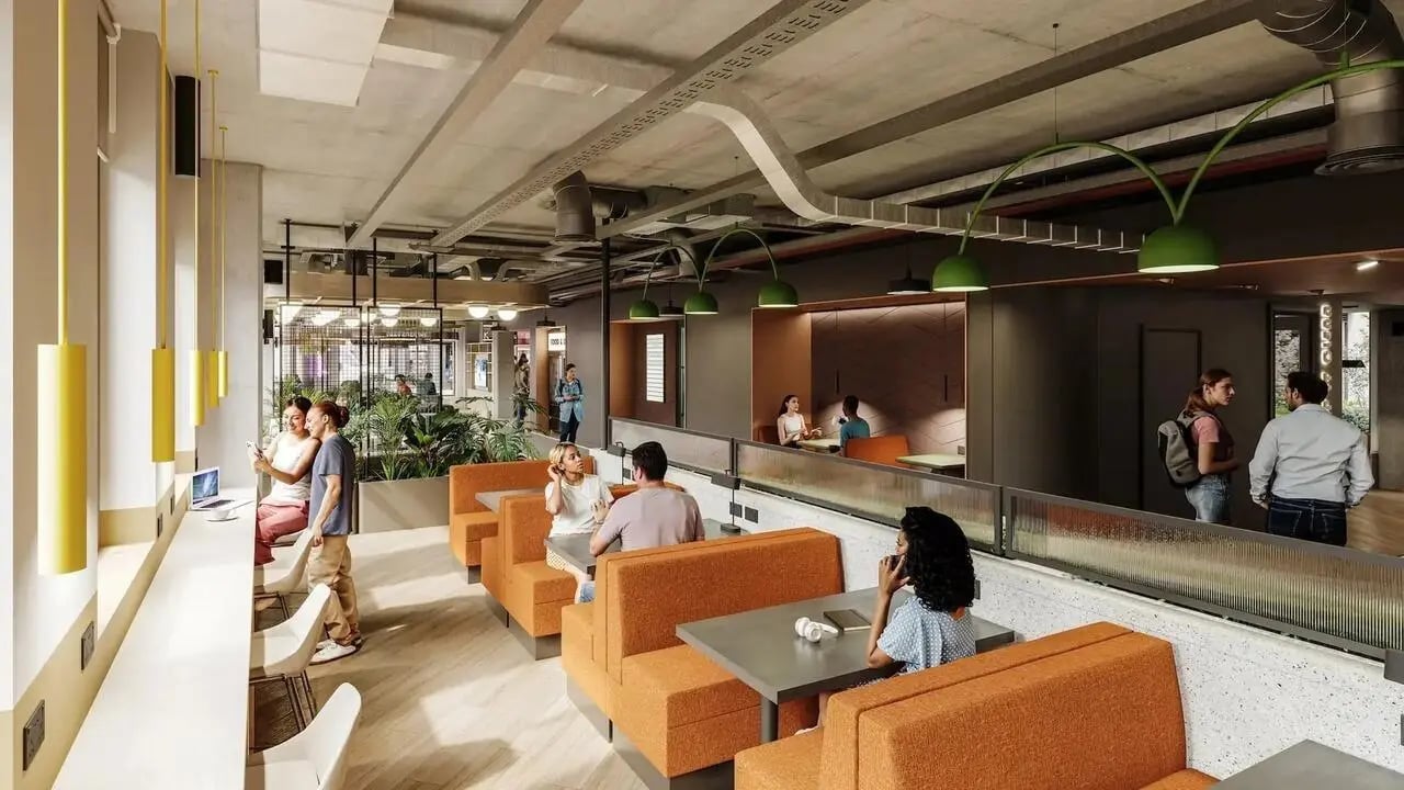 Orange booth seating tables people and plants common area at Signal House in London Student Accommodation